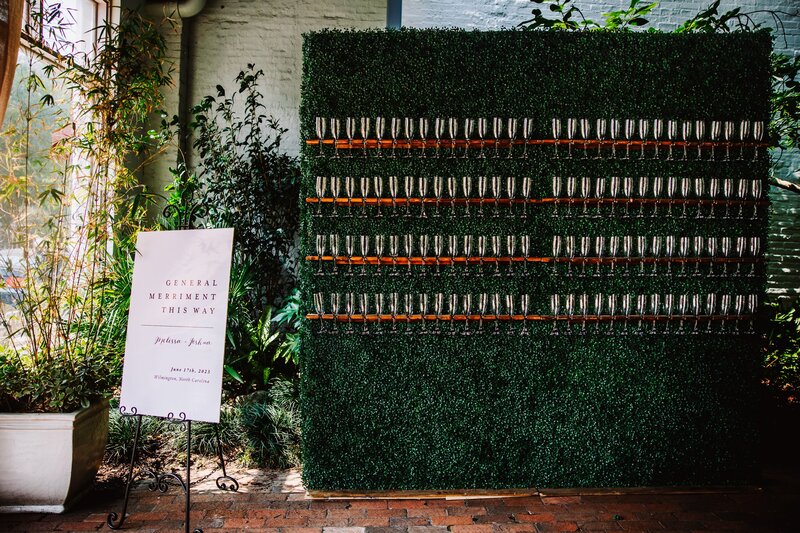 Venue Front Entrance, Welcome Sign, Wedding Day Photography, Champagne Wall, Greenery Background, Brick Flooring, Indoor/Outdoor Venue, Wedding Decor, Wedding Details, Knot Too Shabby Events, Wilmington Wedding Planner, North Carolina Wedding Planner, 
